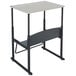 A black Safco stand up desk with a beige top.