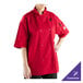 A woman wearing a red Mercer Culinary chef jacket with a full mesh back.