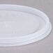 A white plastic Cambro lid with writing and a straw slot.