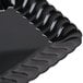 A black Fineline Flairware plastic snack tray with wavy edges.