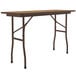 A brown rectangular Correll folding table with black legs.