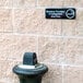 A Thunder Group black and white sign that reads "Smoking Permitted In Designated Areas Only" on a brick wall.