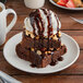 A Tuxton TuxTrendz white coupe plate with brownies, ice cream, and chocolate sauce.