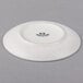 A white Tuxton bread and butter plate with black text on it.