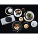 A table set with Tuxton Zion Matte Black china plates, bowls, and food.