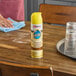 A can of SC Johnson Pledge 14.2 oz. Lemon Enhancing Furniture Polish on a wooden table.