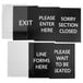 A Lancaster Table & Seating Stanchion sign set with four black and white signs with the words "please exit" in white on a black background.