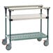 A grey and green metal Metro PrepMate cart with wheels and a shelf.