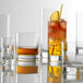 A group of Stolzle New York tumblers filled with different colored drinks.
