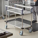 A man using a Metro PrepMate MultiStation with stainless steel shelving in a kitchen.