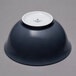 A blue bowl with a white rim on a gray surface.