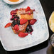 A Schonwald white rectangular porcelain platter with food and fruit on it.