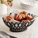 A black plastic oval fast food basket filled with pretzels.