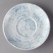 A white porcelain saucer with a blue and white pattern on the bottom.