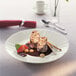 A Schonwald white porcelain plate with chocolate sauce and strawberries on it.