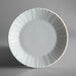 A close-up of a Schonwald white porcelain plate with a wavy edge.