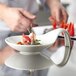 A close-up of food in a Schonwald white porcelain spoon-shaped bowl.