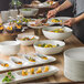 A table set with a Schonwald bone white porcelain bowl filled with food.