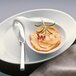 A white Schonwald oval porcelain salad plate with food in a bowl and a spoon.