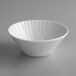 A white Schonwald porcelain bowl with a wavy pattern on a gray surface.