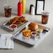 A tray of food with a burger and fries on a Choice quarter size aluminum sheet pan.