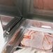 A Turbo Air stainless steel refrigerated sandwich prep table with a tray of sliced ham inside.