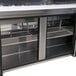 A Turbo Air stainless steel refrigerated sandwich prep table with three doors.