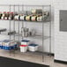 A Regency chrome wire shelf with can racks holding containers and cans.
