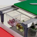 A Metro PrepMate MultiStation Magic Ring with vegetables in a container on a cutting board.