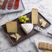 A G.E.T. Enterprises mocha rectangular metal tray with cheese, crackers and grapes on it.