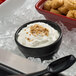 A black G.E.T. Enterprises Bugambilia round metal bowl filled with food on ice.