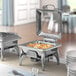 An outdoor buffet with a Acopa Voyage square chafer set and silverware on a table.