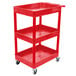 A red Luxor plastic utility cart with three shelves and wheels.