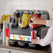 A woman pouring a red frozen beverage from a Vollrath machine into a plastic cup.