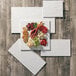 An American Metalcraft white faux slate melamine platter with meat and cheese on a table.