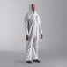 A man in a white Cordova polypropylene coverall with a hood and elastic wrists.
