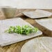 A white rectangular tray with a plate and bowl on a table with a plant.