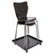 A stack of black Alera steel stacking chairs on a black cart.
