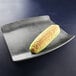 A corn on the cob on an Elite Global Solutions Santiago silverstone rectangular tray.