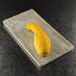 a yellow squash on a white surface