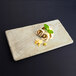A Santiago sandstone rectangular tray with sushi on it.