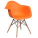 an orange chair with wooden legs