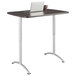 A laptop on a gray rectangular Iceberg sit-to-stand table with silver legs.