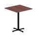 A square Alera cherry/mahogany laminate table top on a table with a black base.