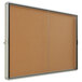 A Quartet enclosed sliding cork bulletin board with a metal frame.