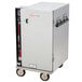A silver stainless steel Metro heated holding cabinet on wheels with black handles.