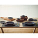 An Ananti walnut wood square tray with dishes on it.