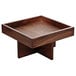 A walnut wood square tall tray on a square table.