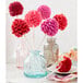A Wilton brown silicone cake pop mold with pink and red frosted cake pops on sticks.