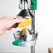 A person using a Garde squeezer to juice a lemon.